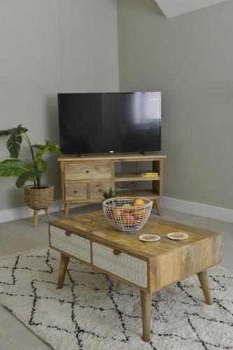 a living room with a tv and a coffee table at Old Green Chambers spacious town centre apartment with free parking! in St. Ives