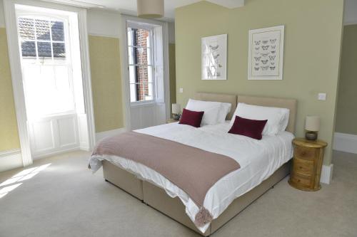 a bedroom with a large bed with red pillows at Old Green Chambers spacious town centre apartment with free parking! in St. Ives