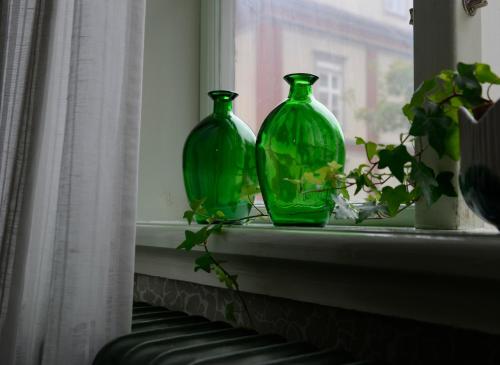two green glass vases sitting on a window sill at Risberg Herrgård in Hagfors