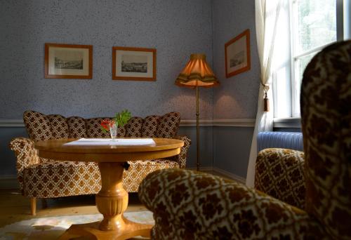 a living room with a table and couches at Risberg Herrgård in Hagfors