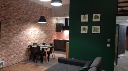 a living room with a table and a green wall at Apartament 5 przy Parku Leśnym in Polanica-Zdrój