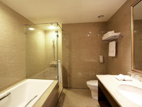 a bathroom with a tub and a toilet and a sink at Classic City Resort in Hualien City
