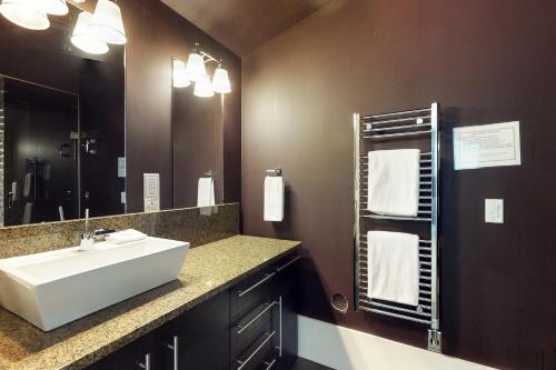 Un baño con un lavabo blanco y un espejo. en Edge 21, en Big White