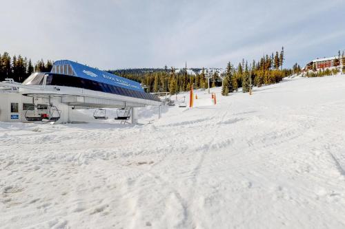 a snow covered ski slope with a building on it at Blacksmith Lodge 7 in Big White