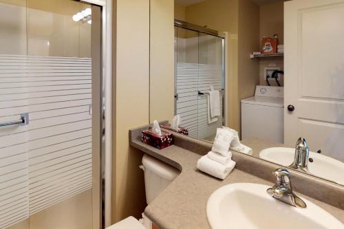 a bathroom with a sink and a toilet and a mirror at Trappers Crossing 28 in Big White