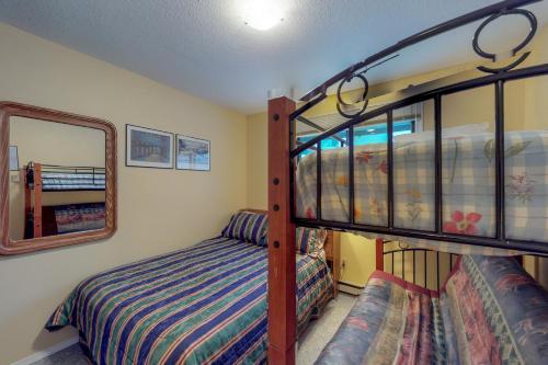 a bedroom with two bunk beds and a mirror at Snow Ghost Inn 326 in Big White