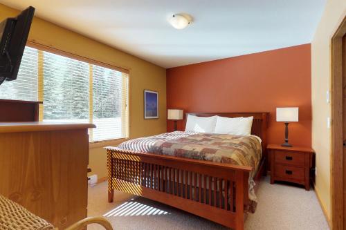 a bedroom with a bed and a window and a television at Silver Tip 6 in Big White