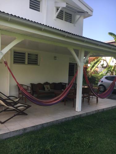 a porch with a hammock on a house at Villa les Palmiers in Les Trois-Îlets