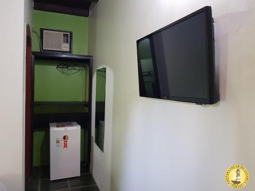 a flat screen tv hanging on a wall at Pousada Solar do Algarve in Paraty