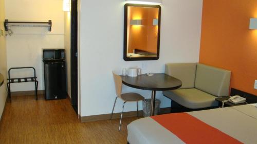 a hotel room with a bed and a table and chair at Motel 6-Oroville, CA in Oroville