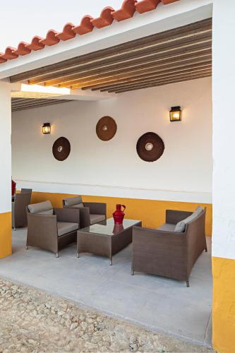 a patio with couches and tables on a building at Casa Brazao Mira in Casa Branca