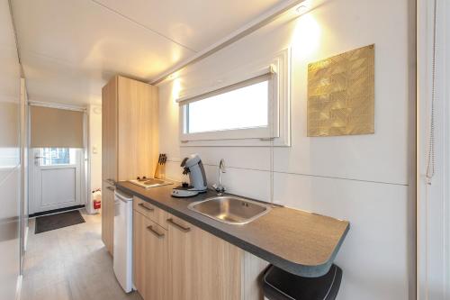 een kleine keuken met een wastafel en een raam bij Tiny floating house, Mallorca in Maastricht