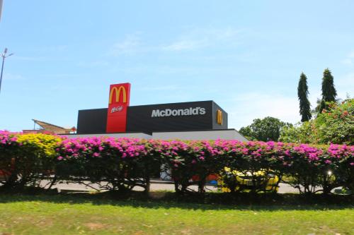 a mcdonalds store with pink flowers in front of it at Nadi Fancy Hotel in Nadi
