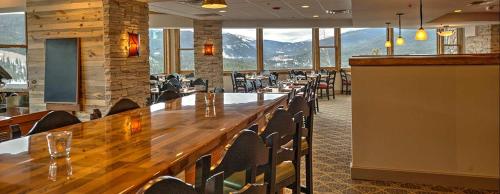 The Lodge at Breckenridge في بريكنريدج: مطعم به طاولة وكراسي خشبية كبيرة