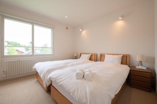 a bedroom with two white towels on a bed at Sakura Apartments in Kutchan