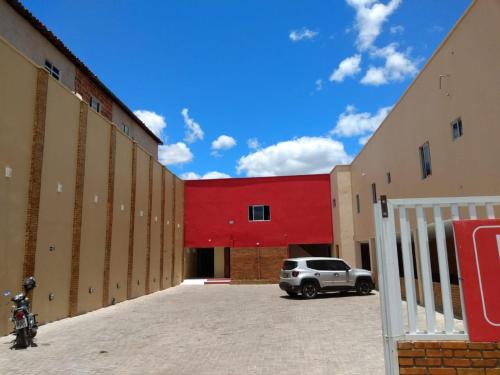 a car parked in a parking lot in front of a building at Pousada Pilotos in Itapipoca