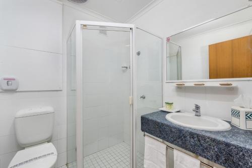 een badkamer met een toilet, een wastafel en een douche bij Tudor Inn Newcastle in Newcastle