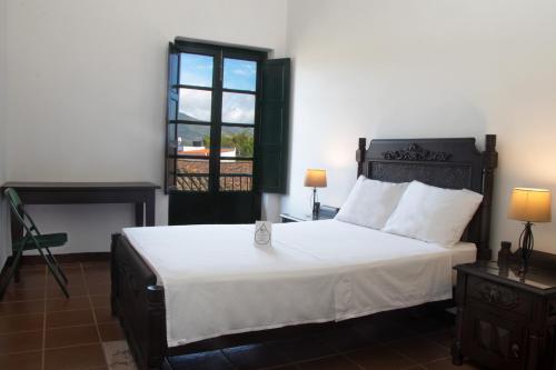 a bedroom with a large bed and a window at El Portón de Enriqueta in Guaduas