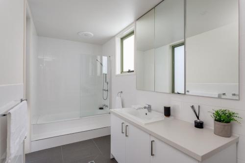a white bathroom with a sink and a shower at Cape Schanck Golf Getaway in Cape Schanck