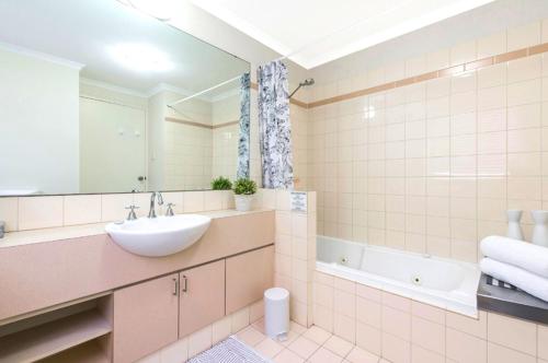 a bathroom with a sink and a tub at Perth West End Apartment 601 in Perth