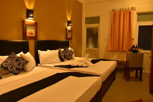 a hotel room with two beds in a room at Nil Diya Mankada Safari Lodge in Udawalawe