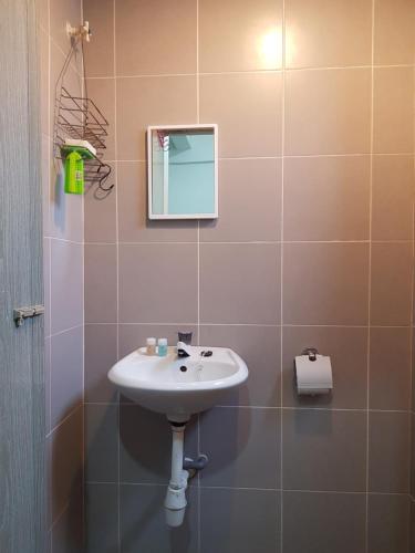 a bathroom with a sink and a mirror at Baoyousongsong in Kampar