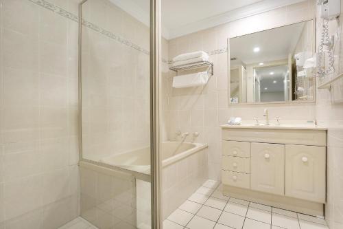 y baño con ducha, bañera y lavamanos. en Wollongong Serviced Apartments en Wollongong