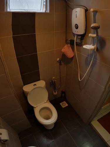 a small bathroom with a toilet and a window at Baoyousongsong in Kampar