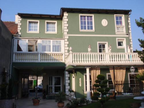 a green house with a white balcony at Villa-Angelina in Langenzersdorf