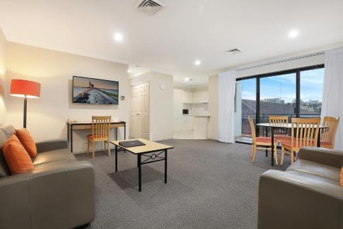 a living room with a couch and a table at Wollongong Serviced Apartments in Wollongong