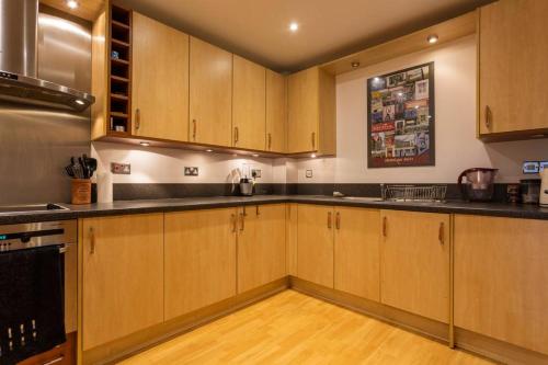 una cocina con armarios de madera y encimeras negras en Cruisers Haven en Southampton