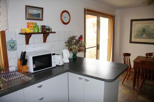 cocina con encimera y microondas en Windmill Cottage en Clare