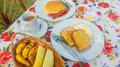 a table with plates of bread and a cup of coffee at Balili Farm At Nacpan Free Motorbike Free Drop Off Free Pick up to town in El Nido