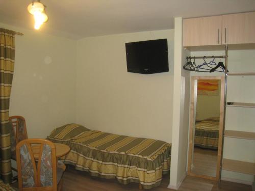 a room with a bed and a tv on the wall at Aroma Skuodiškio Užeiga in Skuodas