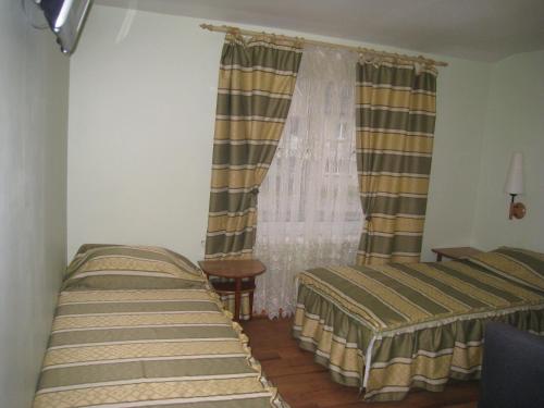 a bedroom with two beds and a window at Aroma Skuodiškio Užeiga in Skuodas