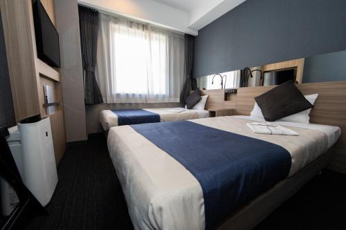 En eller flere senge i et værelse på Quintessa Hotel Osaka Shinsaibashi Comic & Books