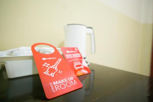 two signs on a table in a room at RedDoorz plus near Pelabuhan Bitung in Bitung