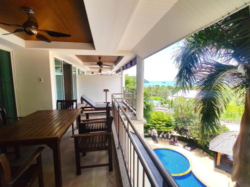 a balcony with a table and chairs and a pool at Spacious apartment with Ocean view in Panwa in Phuket