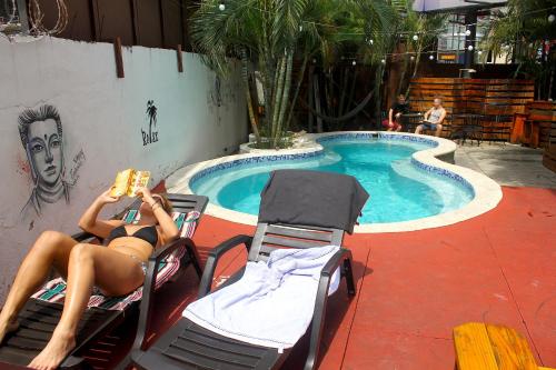 a woman sitting in chairs in front of a swimming pool at Casa Areka in Panama City