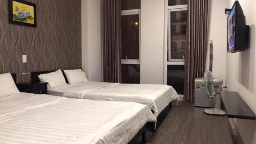 pokój hotelowy z 2 łóżkami i telewizorem z płaskim ekranem w obiekcie Phuong Thao Motel w mieście Da Nang