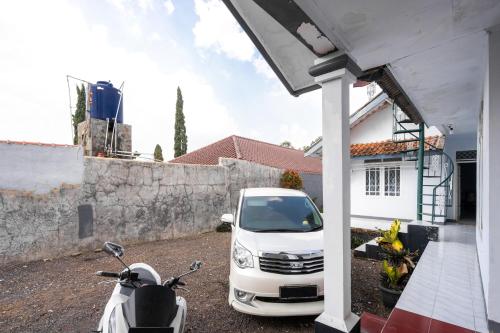 a white van parked in front of a house at RedDoorz Syariah near RSUD Cimacan in Bogor
