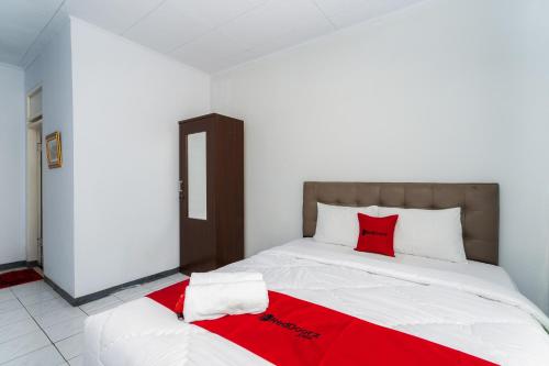 a bedroom with a large bed with red pillows at RedDoorz Syariah near RSUD Cimacan in Bogor