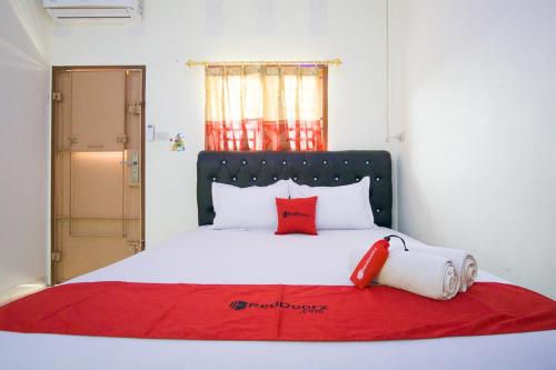 a bed with two red pillows on top of it at RedDoorz @ Pematangsiantar 2 in Pematangsiantar
