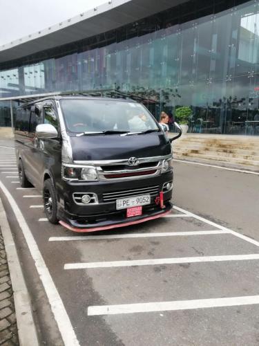 a black van parked in a parking lot at Rainforest Holiday Inn in Deniyaya