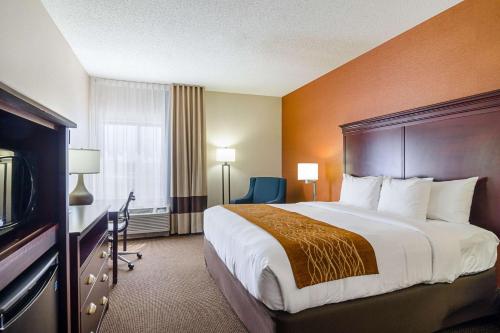 a hotel room with a large bed and a television at Comfort Inn & Suites in Hutchinson