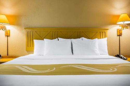 a bed with white sheets and pillows in a hotel room at Quality Inn Pinetop Lakeside in Pinetop-Lakeside