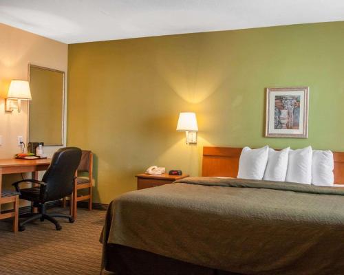 a hotel room with a bed and a desk at Quality Inn Joplin I-44 in Joplin