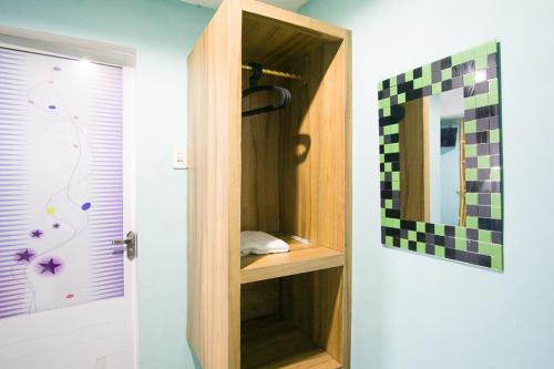 a bathroom with a wooden cabinet next to a door at RedDoorz near Mikie Holiday Funland Berastagi in Berastagi