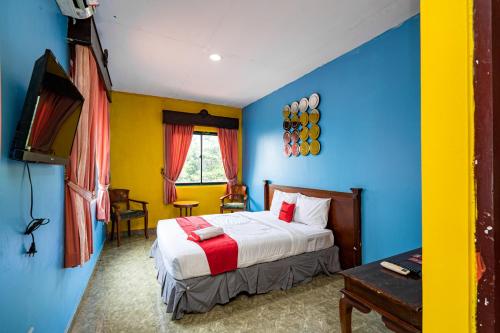 sypialnia z łóżkiem i telewizorem w obiekcie RedDoorz near Istana Bogor w mieście Bogor