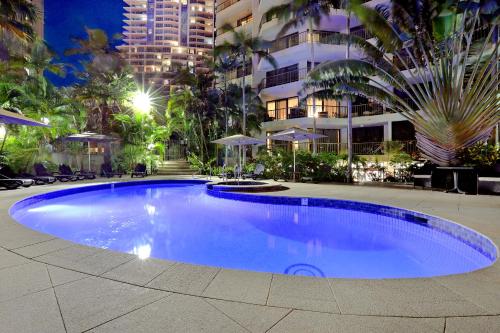a large blue swimming pool in front of a building at Genesis Apartments in Gold Coast